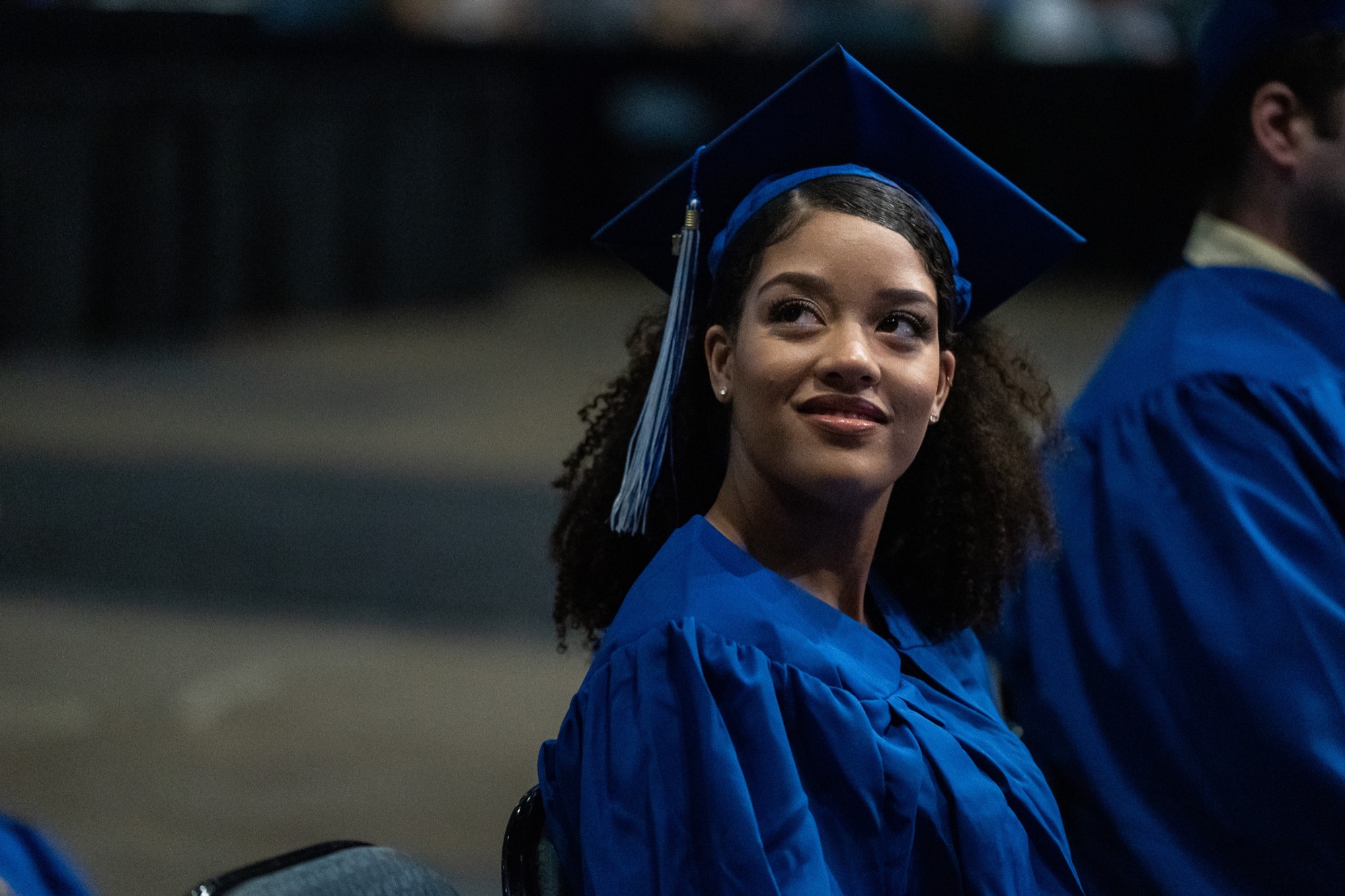 student smiling seated at commencement